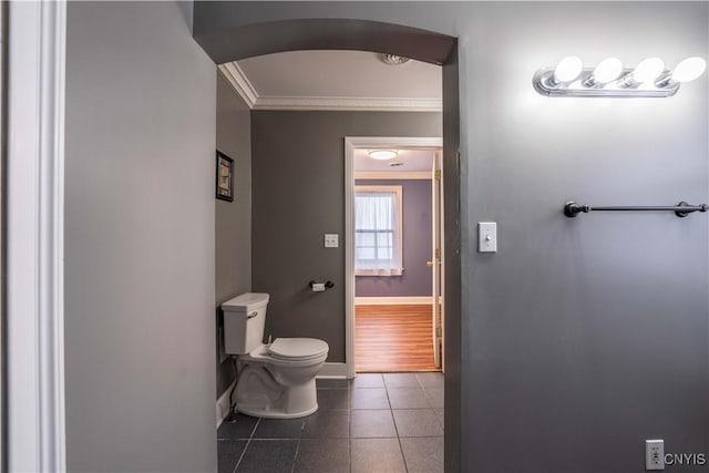 bathroom with tile patterned floors, toilet, and crown molding