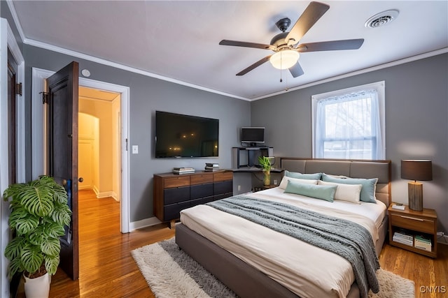 bedroom featuring ceiling fan, crown molding, and hardwood / wood-style flooring