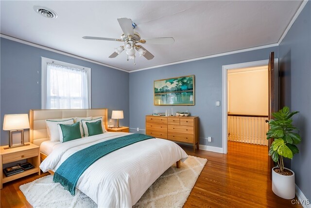 bedroom featuring ceiling fan, dark hardwood / wood-style flooring, and ornamental molding