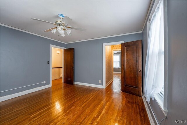 unfurnished bedroom featuring ceiling fan, dark hardwood / wood-style flooring, and crown molding