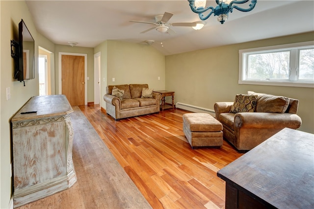 living room with ceiling fan with notable chandelier, lofted ceiling, a baseboard heating unit, and light hardwood / wood-style flooring