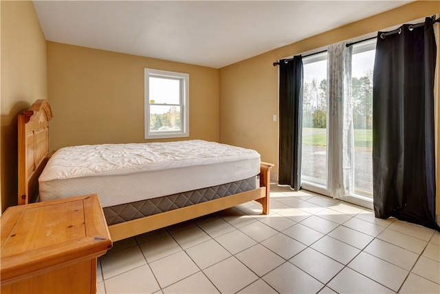 tiled bedroom with multiple windows and access to exterior