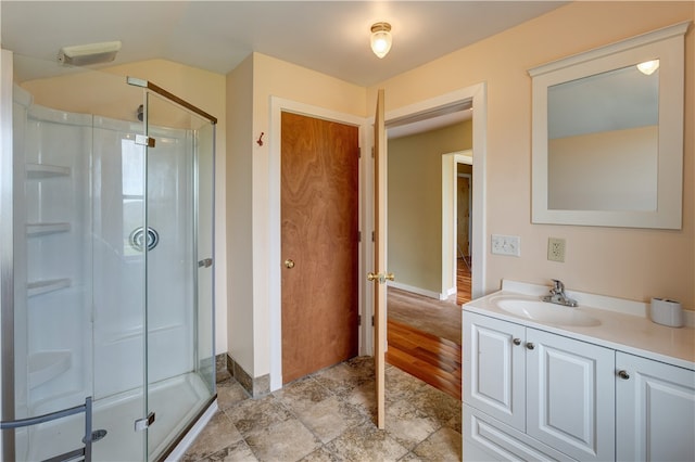 bathroom featuring hardwood / wood-style flooring, vanity, and a shower with shower door