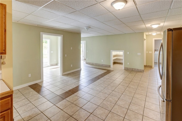 interior space with a drop ceiling and light tile patterned floors