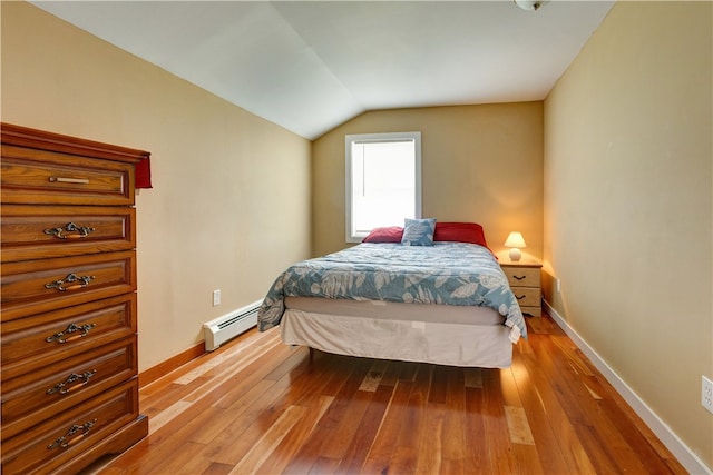 bedroom featuring light wood-type flooring, lofted ceiling, and baseboard heating