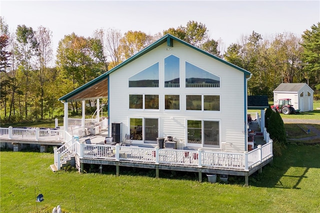 rear view of property featuring a storage shed, a lawn, and a wooden deck