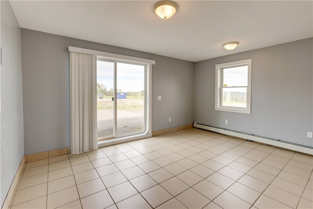 tiled spare room with a baseboard heating unit and a healthy amount of sunlight