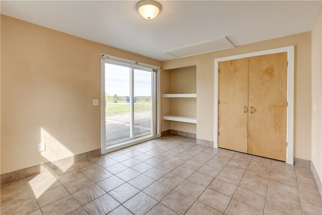 unfurnished bedroom with light tile patterned floors, a closet, and access to exterior