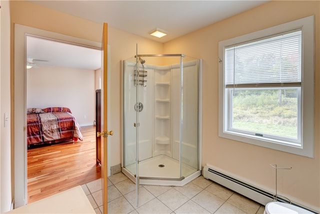 bathroom with ceiling fan, a baseboard radiator, an enclosed shower, and hardwood / wood-style flooring