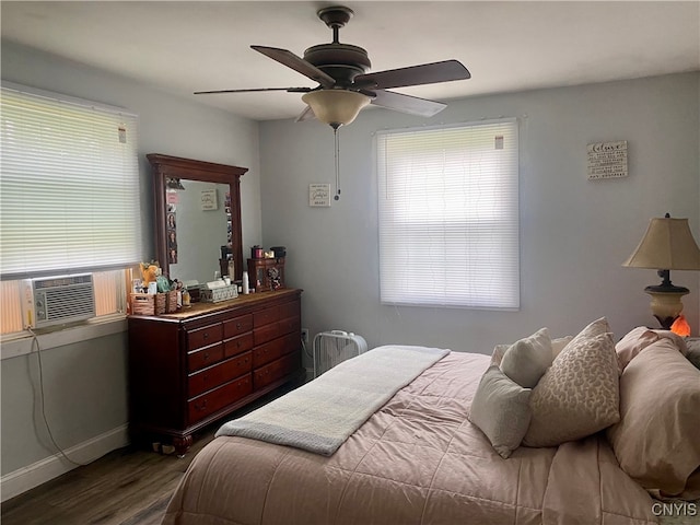 bedroom featuring ceiling fan, cooling unit, dark wood-type flooring, and multiple windows