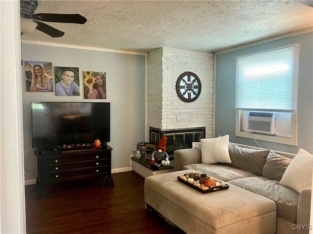 living room with a stone fireplace, a textured ceiling, dark hardwood / wood-style floors, and ornamental molding