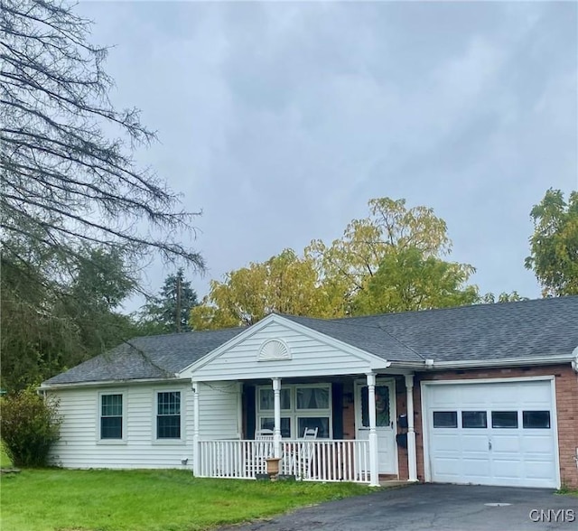 1 Willow Dr, Whitestown, NY 13492 - ranch-style house with a porch, an attached garage, driveway, a front lawn, and a shingled roof