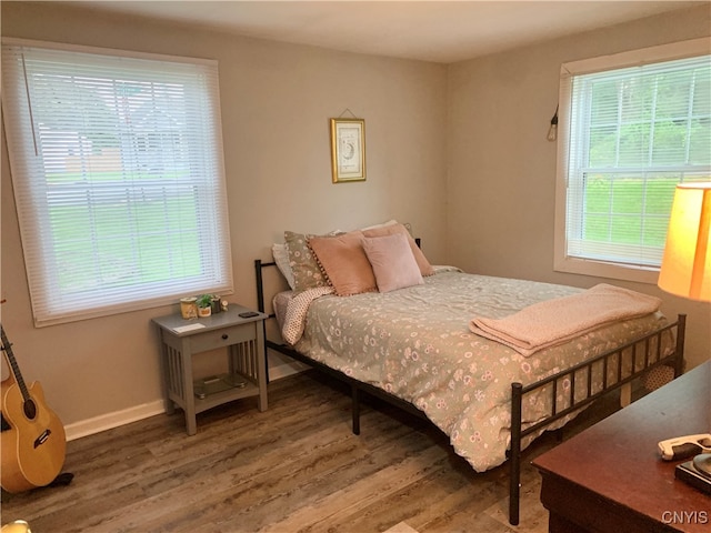 bedroom with multiple windows and hardwood / wood-style flooring