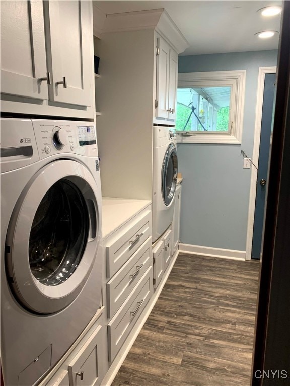 clothes washing area with cabinets, dark hardwood / wood-style floors, and washer and dryer