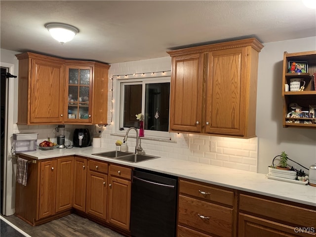 kitchen featuring dishwasher, dark wood-type flooring, sink, decorative backsplash, and light stone countertops