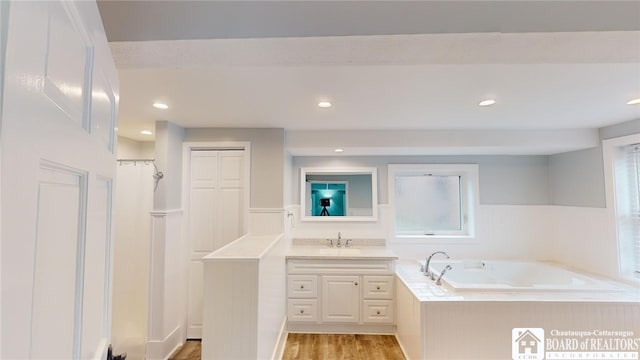 bathroom featuring a bathtub, vanity, hardwood / wood-style floors, and plenty of natural light