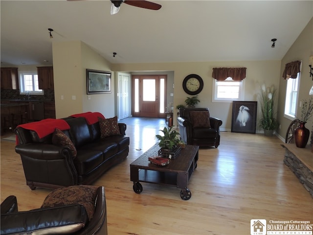 living room with light wood-type flooring, lofted ceiling, and a wealth of natural light