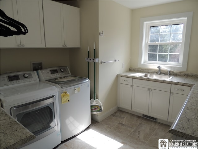 laundry room with cabinets, washer and clothes dryer, and sink