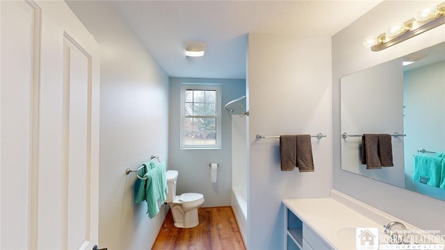 full bathroom featuring wood-type flooring, shower / bathing tub combination, vanity, and toilet