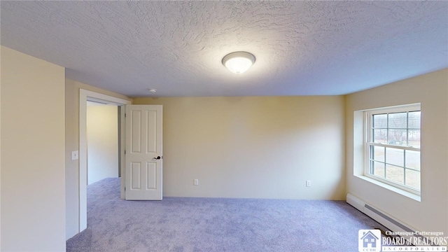 carpeted empty room with a textured ceiling and baseboard heating