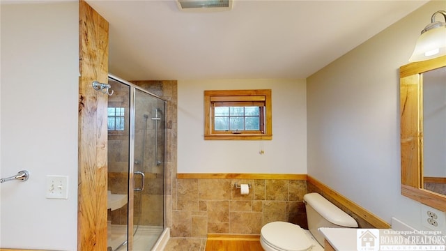 bathroom with walk in shower, vanity, and toilet