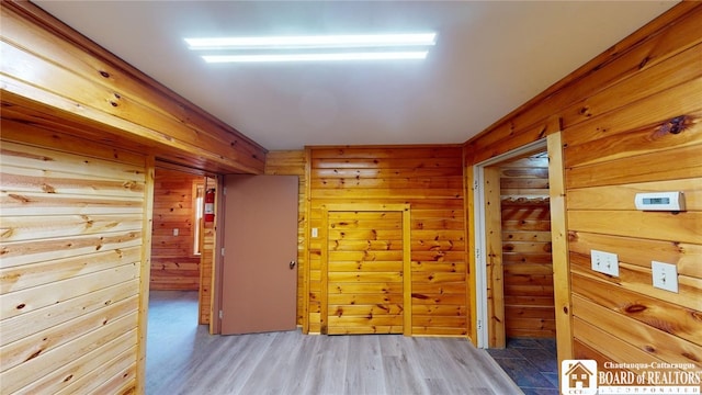 hallway featuring wood-type flooring and wooden walls