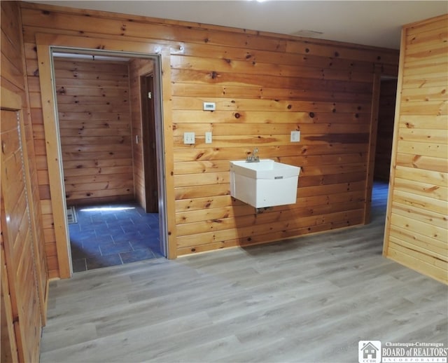 unfurnished room featuring wooden walls and light wood-type flooring