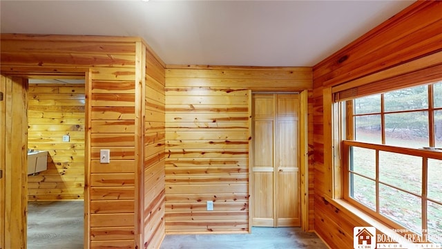 interior space with multiple windows and wood walls