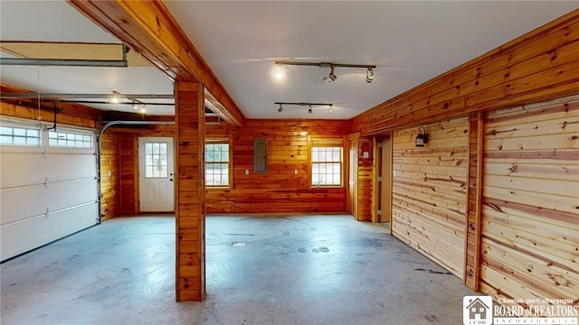 garage with electric panel and wood walls