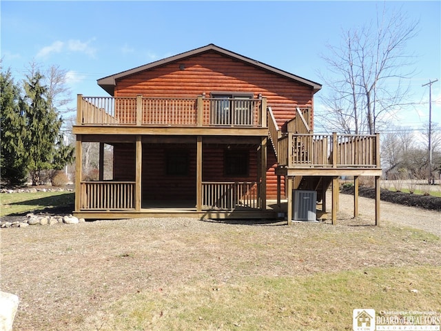 back of property with a lawn, a wooden deck, and central AC