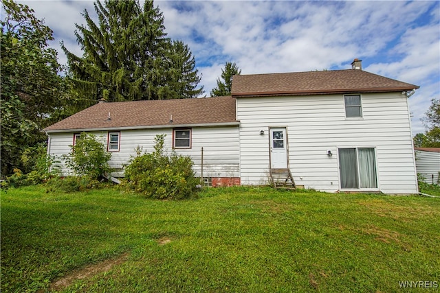 rear view of house featuring a yard