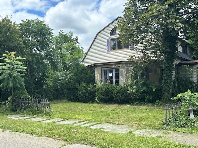 view of property exterior featuring a yard and a gambrel roof