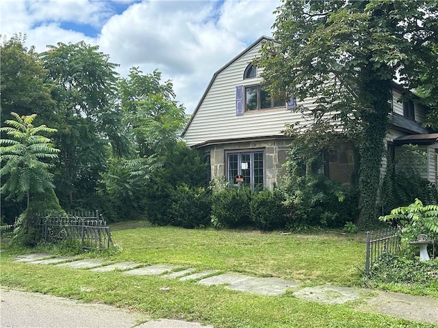 630 W Gray St, Elmira-City, NY 14905 - view of home's exterior featuring a gambrel roof, a yard, and stone siding