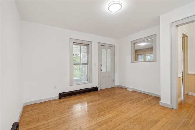 foyer featuring light wood-type flooring and a baseboard heating unit