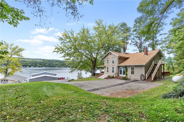 rear view of property featuring a yard and a water view