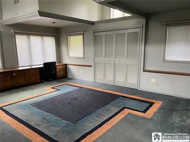 bedroom with built in desk, a closet, and carpet flooring