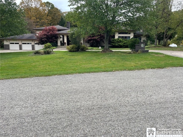 view of front of house with a garage and a front lawn