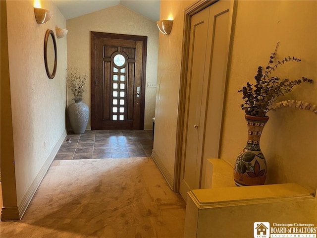 carpeted foyer with lofted ceiling