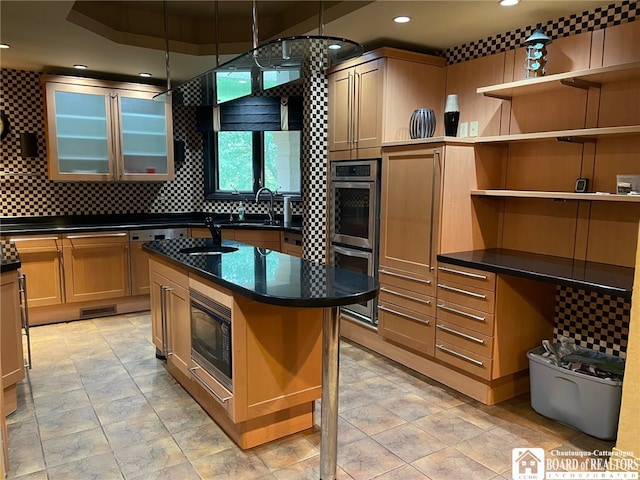 kitchen featuring sink, tasteful backsplash, a kitchen island with sink, stainless steel double oven, and black microwave