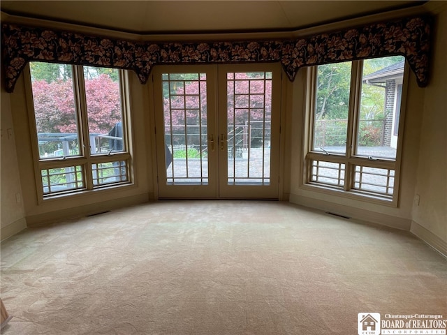 carpeted empty room featuring crown molding and french doors