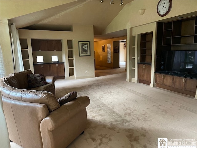 carpeted living room featuring built in shelves and vaulted ceiling