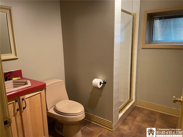 bathroom with tile patterned flooring, a shower with door, vanity, and toilet