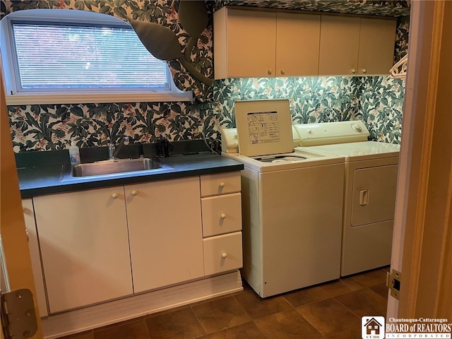 washroom with sink, independent washer and dryer, and cabinets