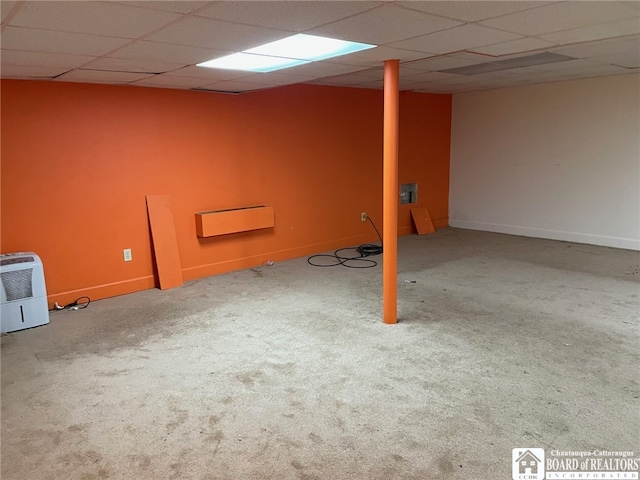 basement with a paneled ceiling and carpet flooring