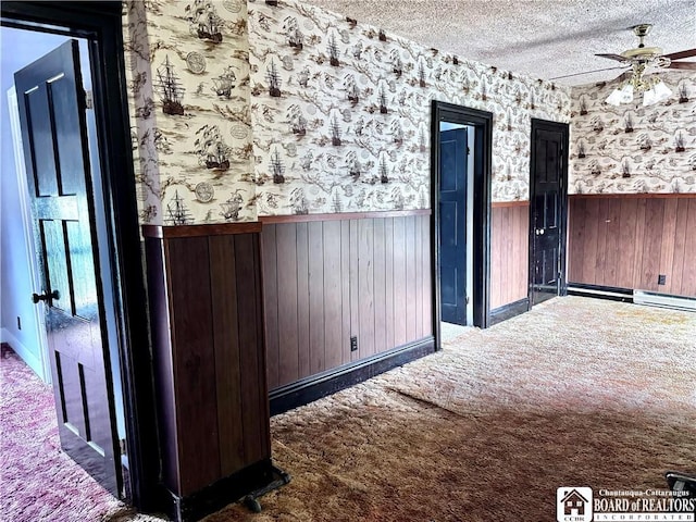 150 N Portage St, Westfield, NY 14787 - interior space featuring a textured ceiling, wainscoting, wallpapered walls, ceiling fan, and carpet
