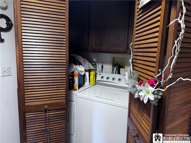 clothes washing area with cabinets and washing machine and dryer