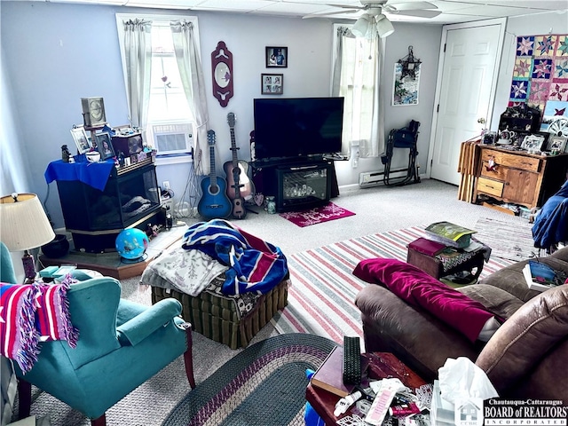 living room featuring ceiling fan, cooling unit, a baseboard radiator, and carpet flooring