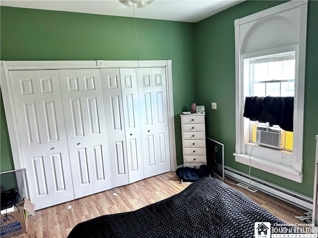 bedroom with cooling unit, hardwood / wood-style flooring, and a closet