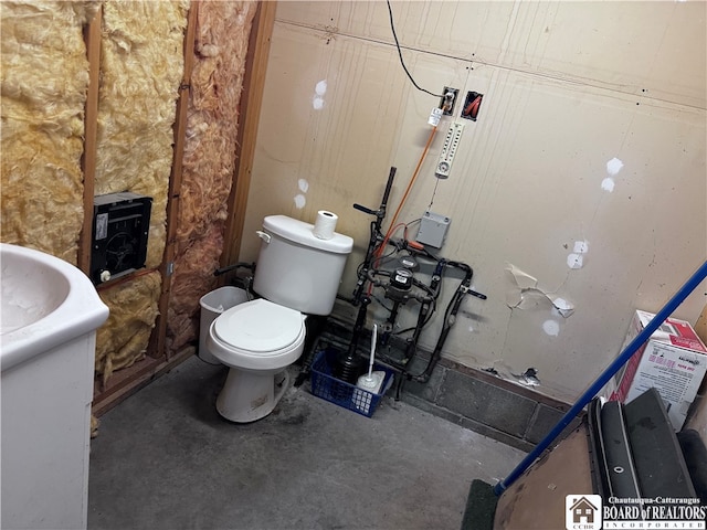 bathroom with concrete floors and toilet