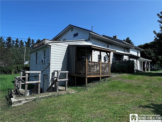 back of property with a lawn and a deck